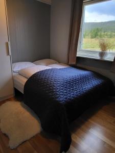 Nord-LenangenIdyllisk hus med sauna og jacuzzi, Lyngen的卧室在窗户前配有一张床