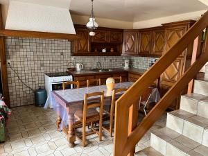 Villers-sur-PortLe Saint André的一间带桌椅和楼梯的厨房