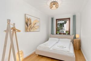 不莱梅Modern Oak-Apartment für bis zu 6 Personen的一间白色卧室,配有床和三脚架