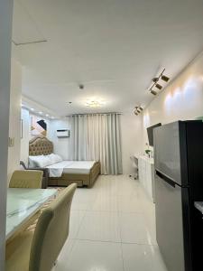 曼达维市Bamboo Bay with Wifi & Pool Condotel的配有床和冰箱的酒店客房