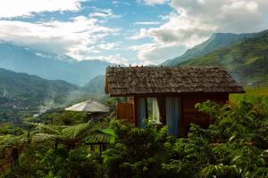 老街市O'chau Homestay Sapa的山丘上的小房子,背景是群山