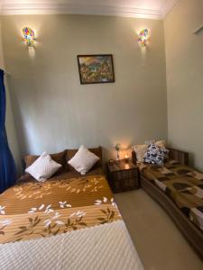 罗纳瓦拉Mystic Dreamville 3BHK Villa Lonavala的一间卧室配有两张床,墙上有两盏灯