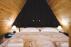 卡兹贝吉Luno Cottage的一间卧室配有一张大床和两盏灯
