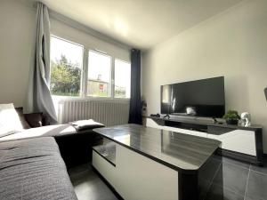 卡尔卡松Maison Bleue ※ Carcassonne的一间卧室配有一张床、一台电视和一张桌子
