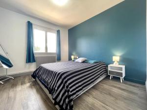 卡尔卡松Maison Bleue ※ Carcassonne的一间卧室配有条纹床和窗户