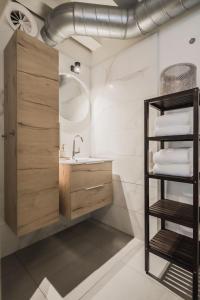 霍林赫姆Le Bon'Apart Suites的浴室设有水槽和带毛巾的架子。