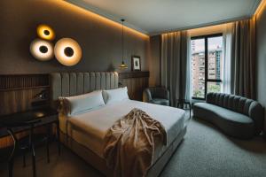 马德里Hotel Pinar Plaza的配有一张床和一把椅子的酒店客房