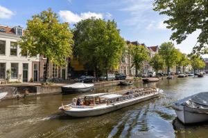 莱顿Breathe Hotel Leiden的一条在城市里沿着河流航行的船