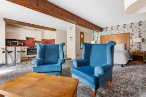 科克勒姆Thurnham Hall Resort的客厅配有2把蓝色椅子和桌子