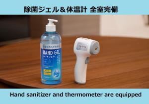 东京Laffitte Hirai Condominium Hotel的一瓶手持消毒器和温度计。