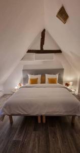 沙托鲁Grand Gîte - Le Saint-Chrirtophe的白色卧室配有一张带黄色枕头的大床
