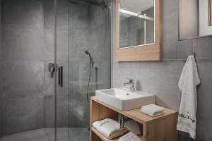 哈拉霍夫Ski & Spa hotel BELLEVUE的一间带水槽和淋浴的浴室