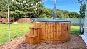 萨希诺Leśna Oaza的后院内带2张长椅的木制热水浴池