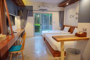 帕克蒙Dugong Village-Green Hotel的一间卧室配有一张床、一张桌子和一张桌子
