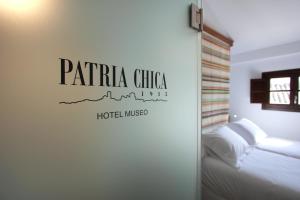 普里埃格·德·科尔多巴Hotel Patria Chica的一间卧室,配有一张床,墙上有标志