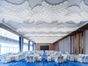 周口周口郸城智选假日酒店的一间会议室,配有白色的椅子和大型天花板