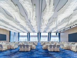 周口周口郸城智选假日酒店的宴会厅配有白色的桌椅