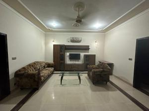 拉合尔Bahria Town - 10 Marla 2 Bed rooms Portion for families only的客厅配有两张沙发和一台电视机