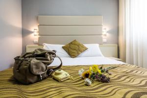 特拉莫Hotel Gran Sasso & SPA的一间酒店客房,配有一张带钱包和鲜花的床