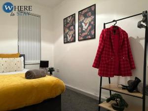KentonStylish 3 bedroom property Newcastle的一间卧室配有一张床和衣架上的红色毛衣
