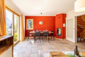 施库尔Arch San Martin B的一间拥有橙色墙壁和桌椅的用餐室