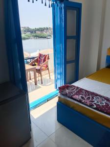 阿斯旺Airkela Nuba Dool2的一间卧室配有一张床,享有船只的景色