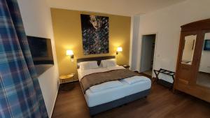 巴特萨尔茨乌夫伦小格鲁纳尔酒店及咖啡馆的卧室配有一张床,墙上挂有绘画作品