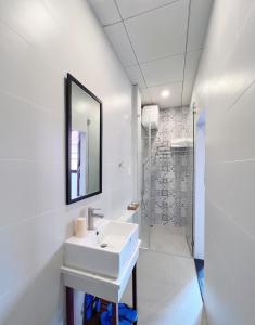 胡志明市Văn Hoa Hotel的白色的浴室设有水槽和镜子