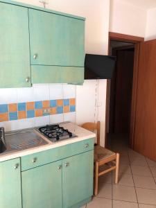 洛萨皮内塔Enjoy your stay in our nice flat with pool的厨房配有绿色橱柜和炉灶。 顶部烤箱