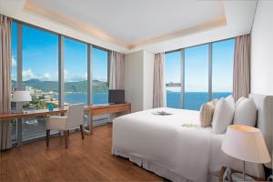 岘港乐卡尔特岘港海滩酒店的酒店客房设有一张床和一张书桌,享有美景。