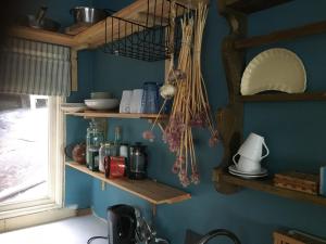 韦姆德Sjöstuga, Archipelago Beach House的厨房设有蓝色墙壁上的木制架子
