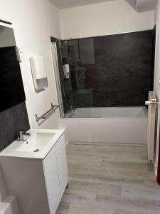 敦刻尔克Hôtel Les Jardins Dunkerque centre的浴室配有白色浴缸、盥洗盆和浴缸。