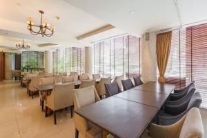 曼谷Lantana Resort Hotel Bangkok的用餐室设有桌椅和窗户。