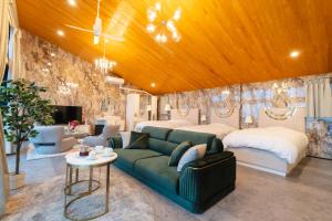 NomaGlamping＆Resort WOOD DESIGN PARK NOMA的一间卧室配有绿色沙发和两张床
