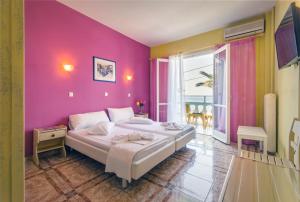 库卡里Kokkari Beach Hotel的一间卧室配有一张带粉红色墙壁的大床