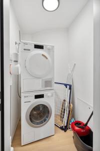 苏黎世Zurich Flat: Central & Lake Convenience的洗衣房内的洗衣机和烘干机