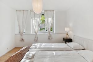 苏黎世Zurich Flat: Central & Lake Convenience的一间白色卧室,配有两张床和窗户
