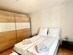 舍讷费尔德Gemütliche Wohnung mit Balkon in Schönefeld的一张白色的床,上面有两条毛巾