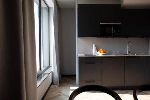 阿姆斯特丹Bob W Amsterdam Noord的厨房配有黑色橱柜、水槽和窗户。