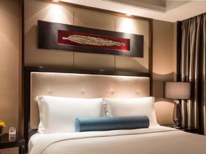 上海上海静安铂尔曼酒店的卧室配有一张白色大床和蓝色枕头