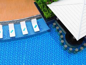 芭东海滩Grand Mercure Phuket Patong的享有蓝色瓷砖游泳池的顶部景色