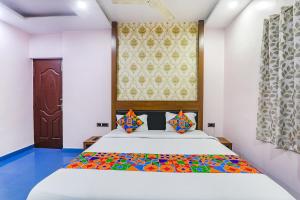 加雅FabHotel Astor的一间卧室配有一张大床和色彩缤纷的毯子