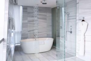 杜尚别杜尚别凯悦酒店的带浴缸和玻璃淋浴间的浴室。