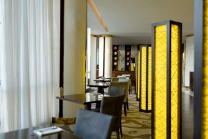 杜尚别杜尚别凯悦酒店的用餐室配有桌椅和黄色灯光