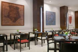 阿兰约兹帕拉西奥亚兰珠斯NH精选酒店的餐厅设有桌椅,墙上挂有绘画作品