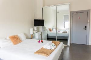 古尔本Exchange Hotel Goulburn的卧室配有白色的床和镜子
