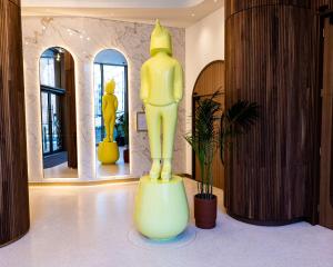 伦敦art'otel London Battersea Power Station, Powered by Radisson Hotels的镜子间里的一个黄色大雕像