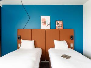 鲁昂坎帕尼尔罗恩梅尔莫兹旅馆的蓝色墙壁客房的两张床
