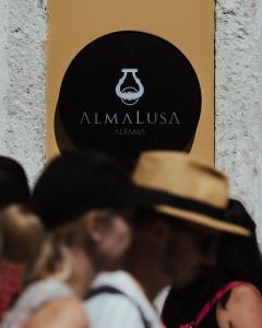 里斯本AlmaLusa Alfama的一群戴帽子的人站在标志前