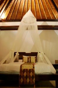 塞米亚克坎提克特雷桑别墅酒店的一间卧室配有一张带蚊帐的床